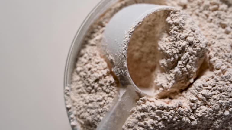 Protein powder in a bowl and scoop. Food supplement sport nutrition