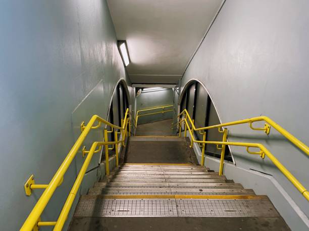 istock Staircase in tunnel walkway with yellow railings 1454156080