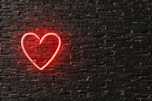 istock 3D neon pink sign hanging on black brick wall 1454156337