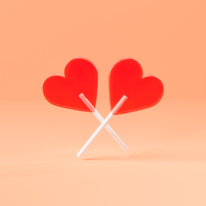 3D rendering of heart shaped sweet red lollipops on white sticks crossed against beige background
