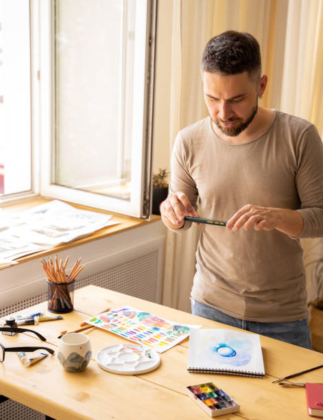 istock A creative person creates digital content for social networks. The artist is in his workshop. The young artist sends photos of his works via messenger. DIY concept, painting studio 1454156971