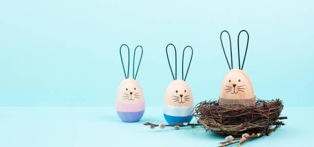 istock Easter bunny or rabbit group with wicker basket, willow branches, wooden egg, spring holiday greetings 1454159304