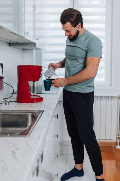 istock Young man pouring himself a cup of coffee 1454160353