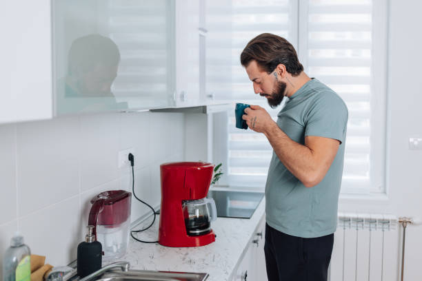 istock Man taking a sip of coffee 1454160421