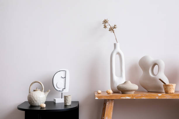 istock Scandinavian composition with wooden bench, black coffee table, sculpture, decoration, dried flowers in white vase and personal accessories. Stylish and minimalist home decor. Template. 1454161965