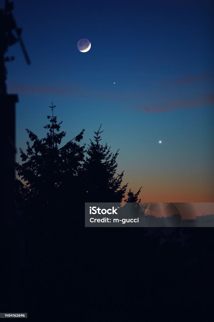Moon with planet conjunction on evening urban sky. Venus - Planet Stock Photo