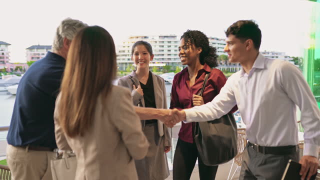 Corporate associates shaking hands in open-air cafe
