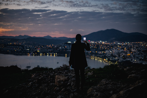 Young Woman Shooting Cityscape at Sunset With Her Smartphone