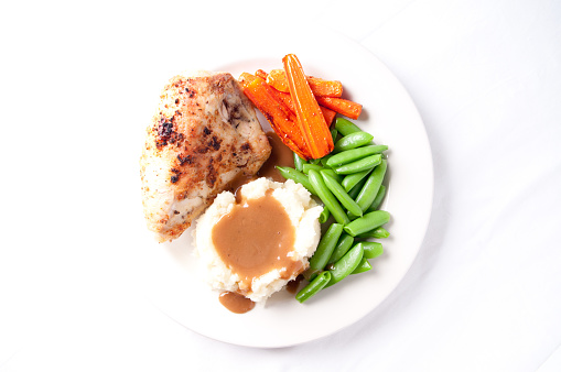 A thanksgiving Day turkey on a platter fully cooked and dressed isolated on a white background.