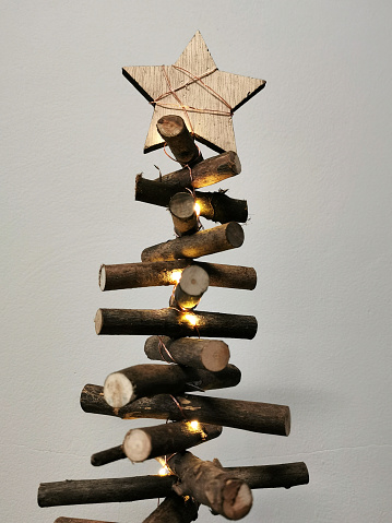 A wooden Christmas tree made of sticks with a star on top