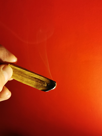 Lit incense on a red background