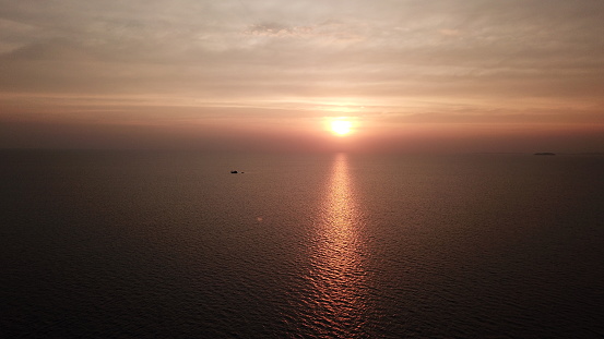 Sunset reflection sun sea twilight sky at Munnork, Thailand. Aerial view scenic view. Drone shot of landscape beautiful and colorful clouds. New journey explorer naval ship cruising fishing boat trip yacht.