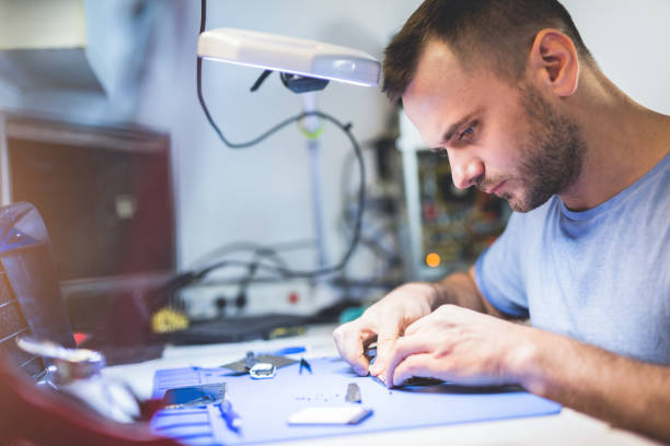 istock Man repairing mobile phone electronics service shop 1454173446