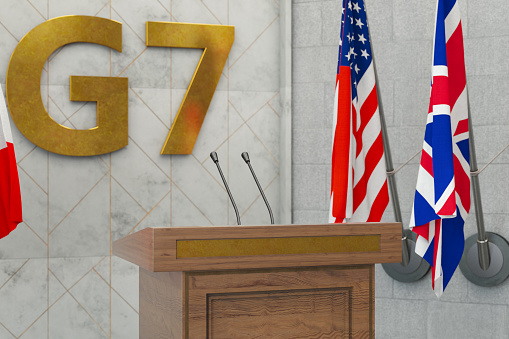 American flag draped around a judge's gavel block and the United States Constitution for use as a symbol of laws, freedom and separation of government powers.