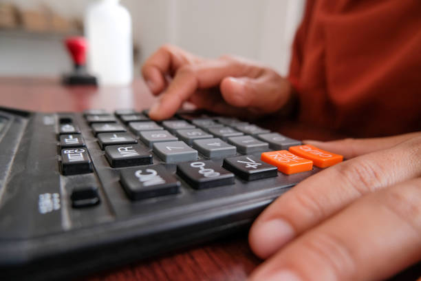 istock close up of hand using a calculator 1454176566