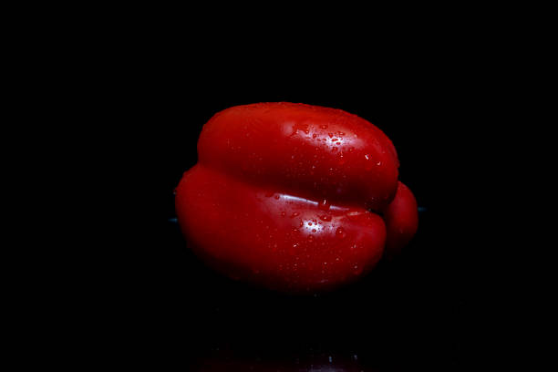Washing red bell peppers.