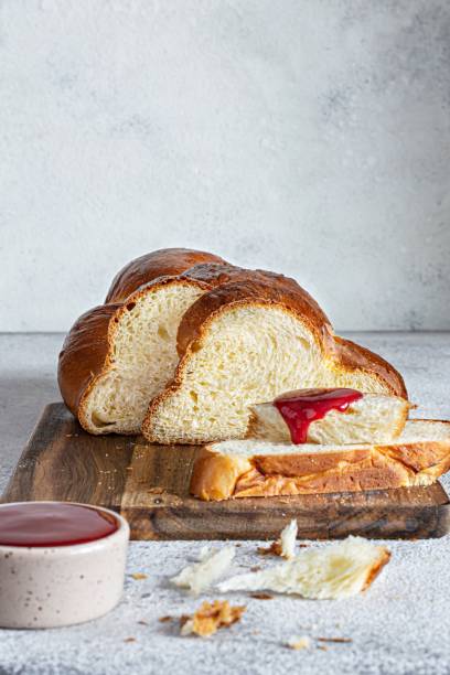 халла или хала – это традиционный еврейский сладкий свежий субботний плетеный хлеб (буханка), свежая булочка с начинкой на разделочной дос� - vendee стоковые фото и изображения