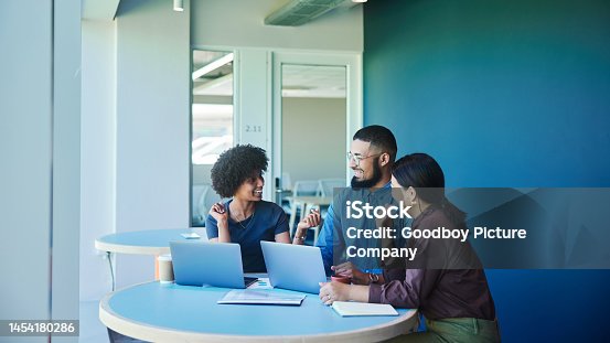 istock Young businesspeople laughing during a casual meeting in an office 1454180286