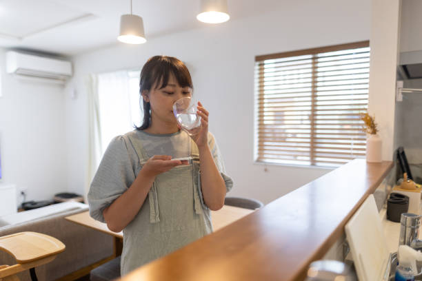 istock Woman taking supplement at home 1454181503