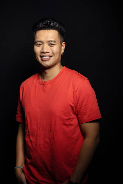 istock Confident young asian man posing on black background. 1454185386