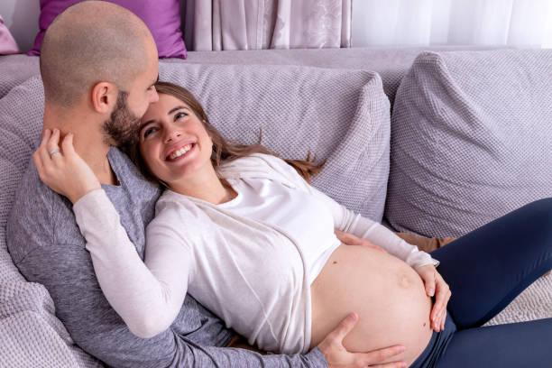istock A happy expecting couple resting on the sofa. 1454185515