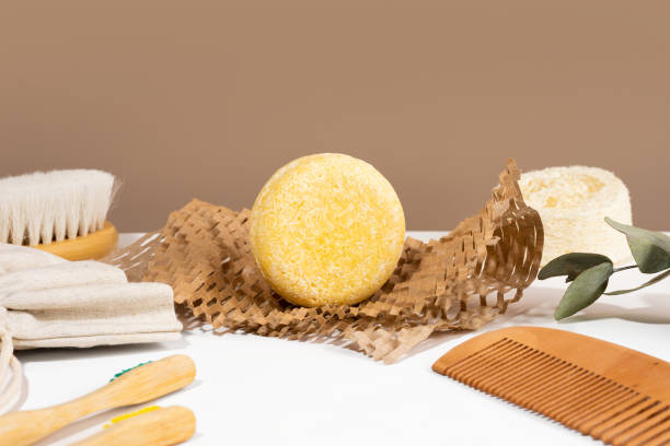 istock Eco friendly solid shampoo bar on a Honeycomb Paper and natural materials bathroom accessories lying on a white and brown background. Plastic free, zero waste, low water ingredients. Copy space 1454185837