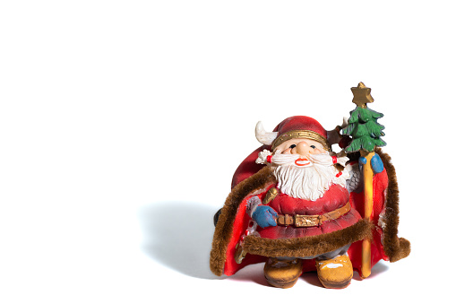 A closeup shot of a small statue of Viking Santa Clause on a white surface