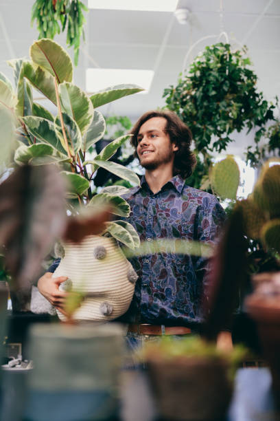 istock Young man working in florist shop. 1454187337