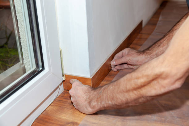 istock Worker, Carpenter installing laminate flooring. Installing molding trim Vinyl Plank Flooring. 1454187537