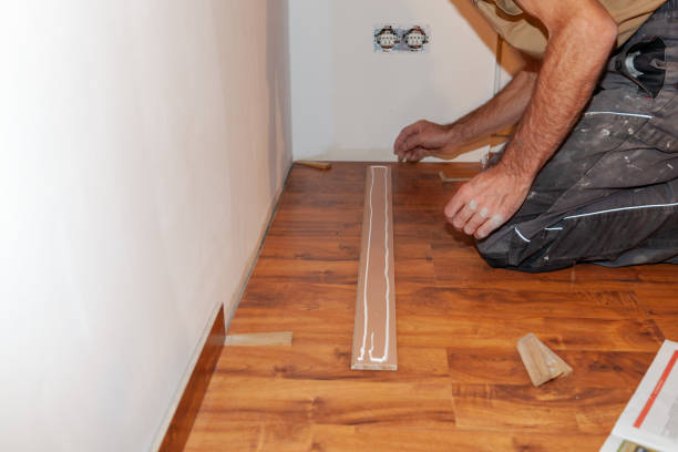 istock Worker, Carpenter installing laminate flooring. Installing molding trim Vinyl Plank Flooring. 1454187676