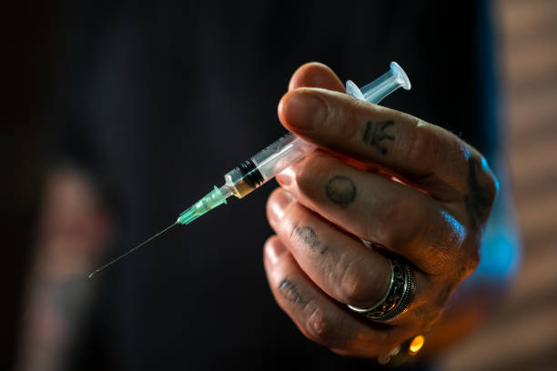Heroin Man holding in hand syringe with drug drug addiction tattoos stock pictures, royalty-free photos & images