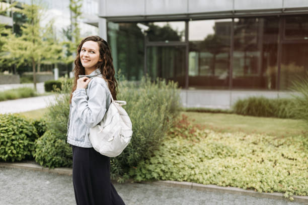 istock Happy pretty young brunette woman with backpack 1454189151