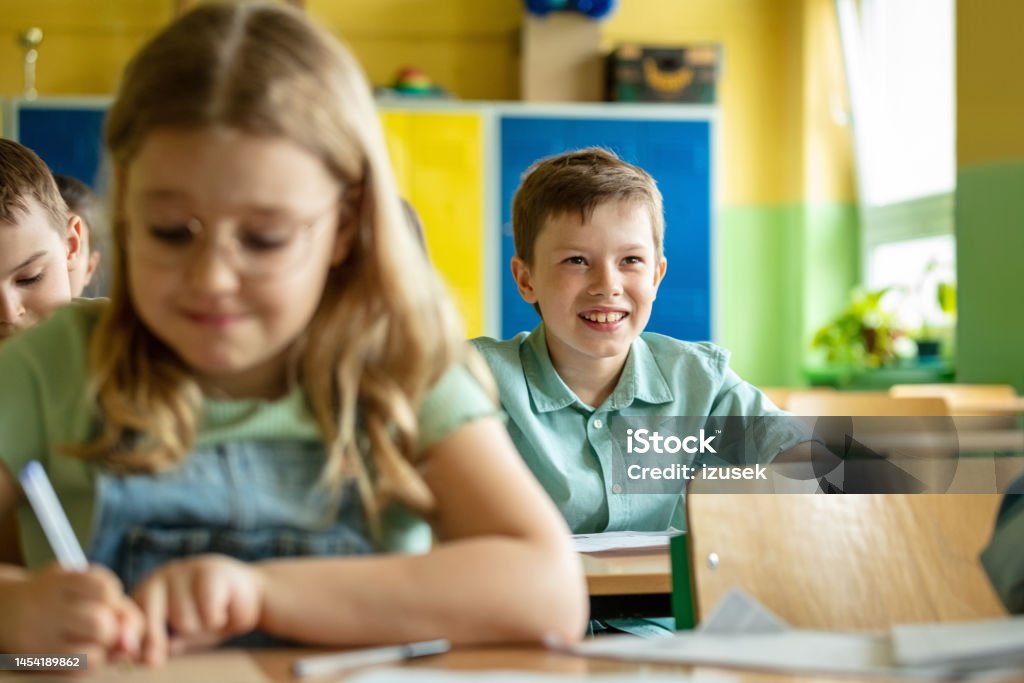 School boy answering during lesson Children sitting at the desks in the classroom in the elementary school. Focus on boy answering during lesson. 8-9 Years Stock Photo School boy answering during lesson Children sitting at the desks in the classroom in the elementary school. Focus on boy answering during lesson. 8-9 Years Stock Photo