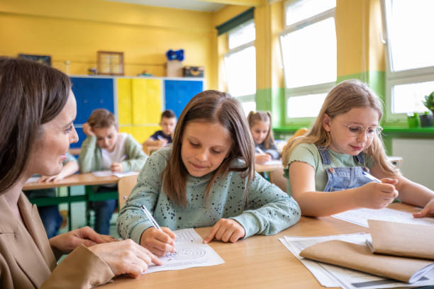 istock Schoolgirls learning together in the classroom 1454191521