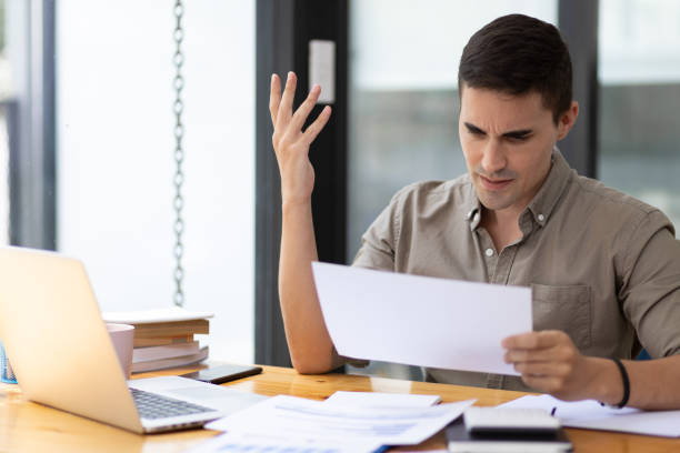 istock Handsome young businessman in the office serious about work analyzing documents and planning financial accounts. 1454192255