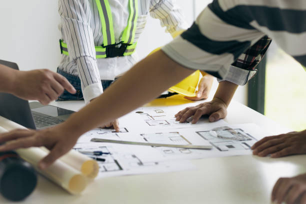istock Architect and engineer colleagues brainstorm design work on blueprint planning ideas of construction projects. Construction engineering design inspector team. 1454192348