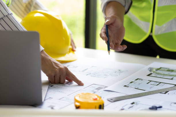 istock Architect and engineer colleagues brainstorm design work on blueprint planning ideas of construction projects. Construction engineering design inspector team. 1454192356