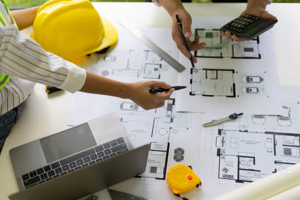 istock Architect and engineer colleagues brainstorm design work on blueprint planning ideas of construction projects. Construction engineering design inspector team. 1454192367