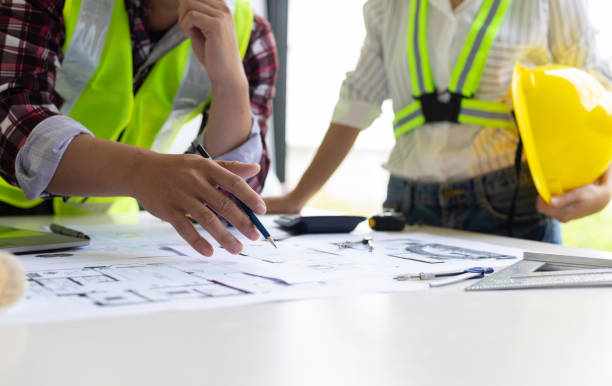 istock Architect and engineer colleagues brainstorm design work on blueprint planning ideas of construction projects. Construction engineering design inspector team. 1454192390