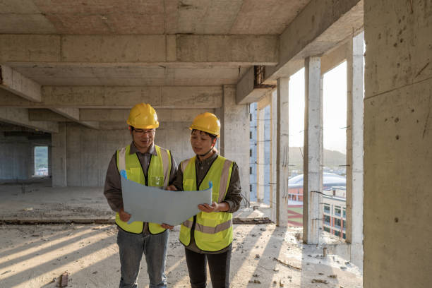 istock Male and female workers are working on the construction site with engineering drawings 1454192644