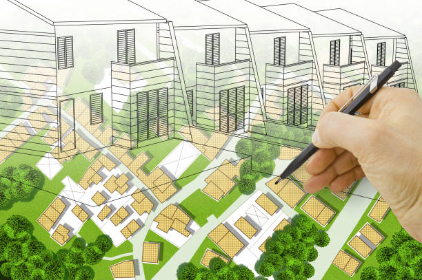 istock Architect drawing a residential building over an imaginary cadastral map of territory with buildings, land plots and green areas with gardens and trees 1454194148