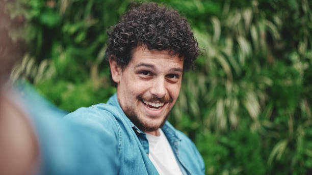 istock Close-up, young bearded man doing stream, video call on green leaves background 1454194157