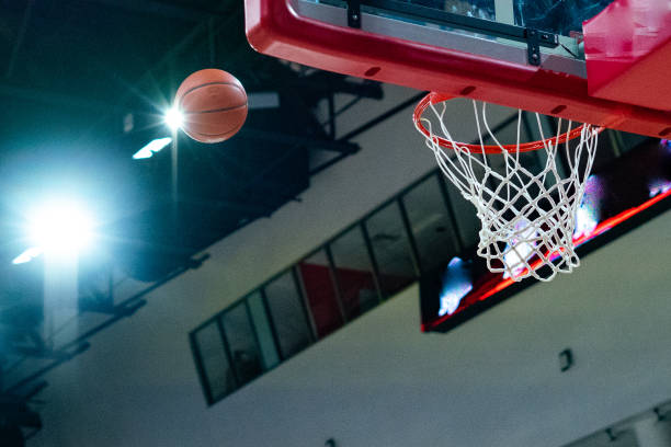 istock Basketball shot heading toward backboard and net 1454198366