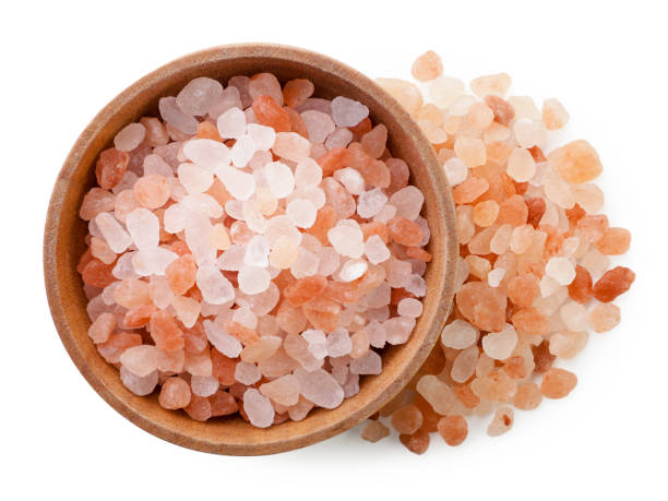 istock Himalayan salt in a wooden plate on a white background. Top view 1454199456