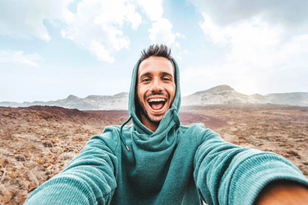 istock Handsome man taking selfie photo with smart mobile phone device outside - Cheerful climber hiking mountains - Travel blogger, people and action camera concept 1454201954