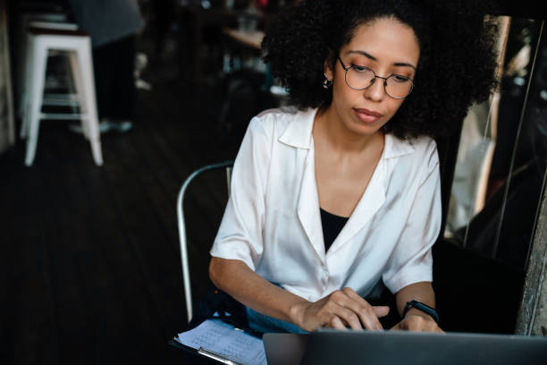 istock Young african american woman using laptop while working in cafe 1454204727