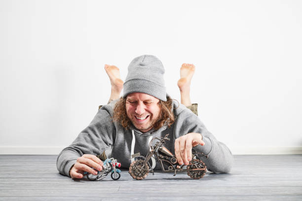 Dad playing with toy motorcycles on the floor
