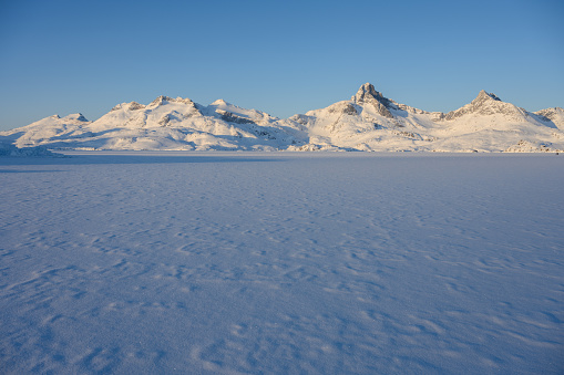 View over the frozen Tasiilaq Fjord at sunset, located in East Greenland.