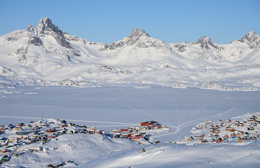 View over the frozen Tasiilaq Fjord, located in East Greenland. The settlement of Tasiilaq is visible in the foreground.