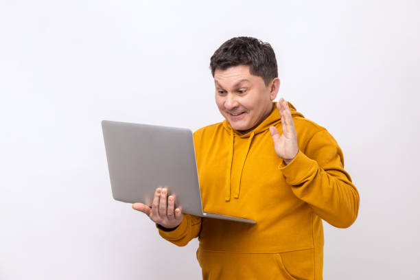 istock Man waving hand gesturing hello to laptop screen, talking on video call with coworker. 1454208569